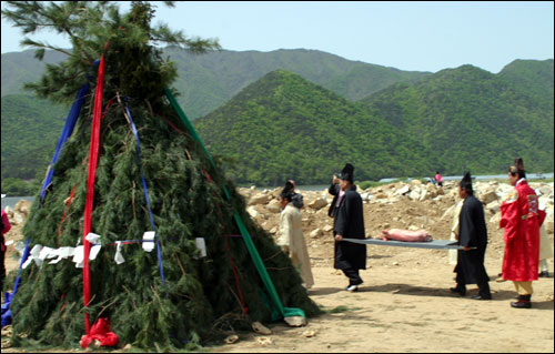 제물로 올릴 돼지를 들고 송막 주변을 한바퀴 돌고 있다 